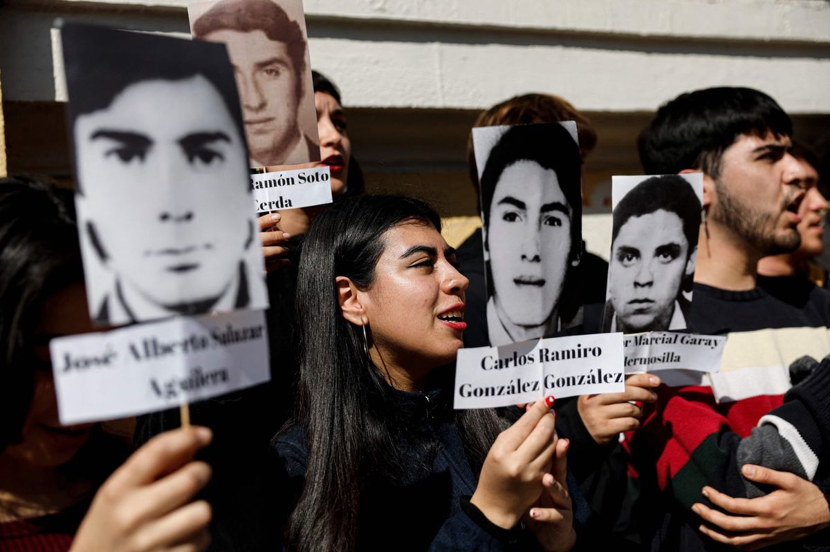 Des étudiants de l’Université du Chili manifestent en brandissant les photos de personnes disparues sous la dictature d’Augusto Pinochet. Santiago, 30 août 2023. 