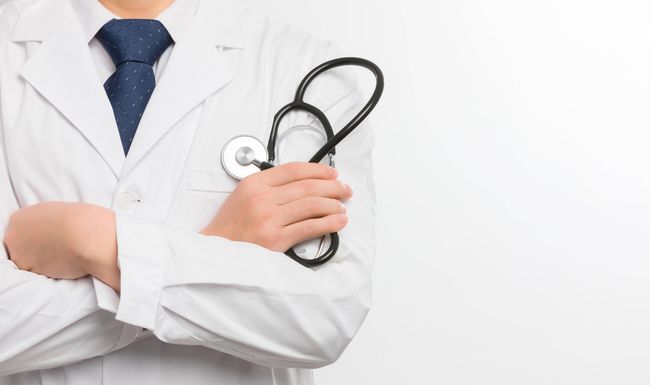 Asian male doctor with his hands on his chest on a white background PUBLICATIONxNOTxINxCHN 805000746780196946 ,model released, Symbolfoto