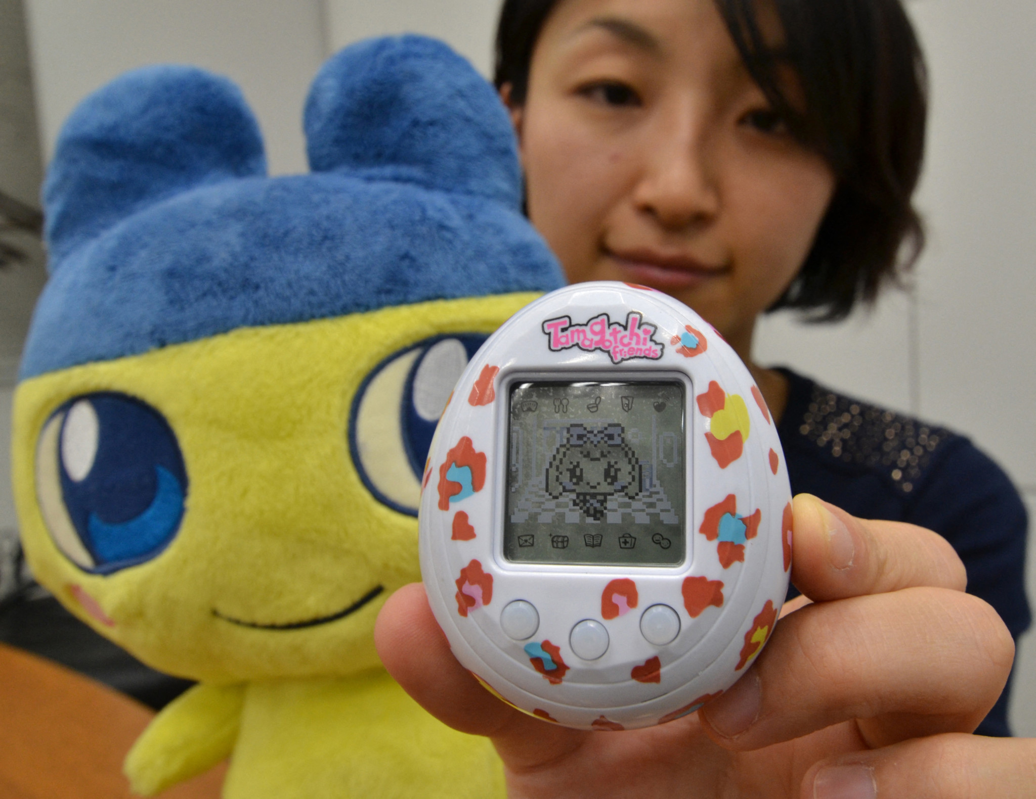 Une employée de Bandai, Tomomi Washizu, présente le nouveau jouet Tamagotchi Friends, en forme d’œuf, à Tokyo.
