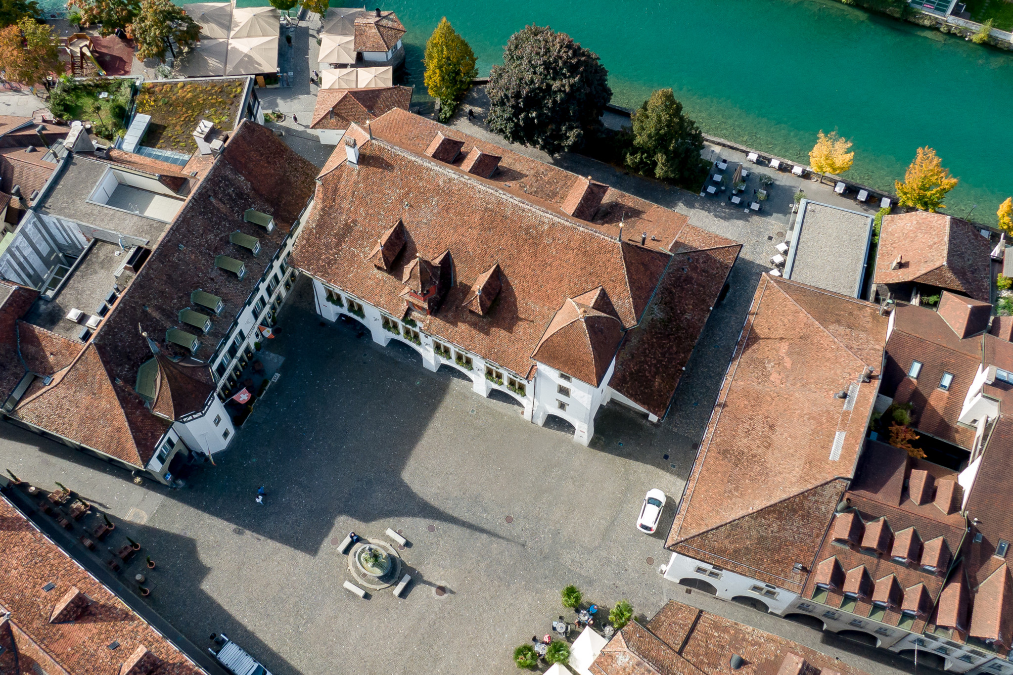 Luftaufnahme des Rathauses Thun mit rotem Ziegeldach, Innenhof und dem Fluss Aare im Hintergrund. Luftaufnahme des Rathauses Thun mit rotem Ziegeldach, Innenhof und dem Fluss Aare im Hintergrund.