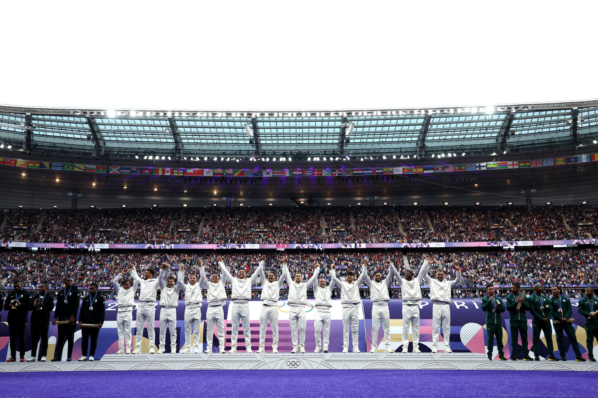 PARIS, FRANCE - JULY 27: Gold medalists of Team France celebrate on the podium during the Men’s Rugby Sevens medal ceremony on day one of the Olympic Games Paris 2024 at Stade de France on July 27, 2024 in Paris, France. (Photo by Cameron Spencer/Getty Images)