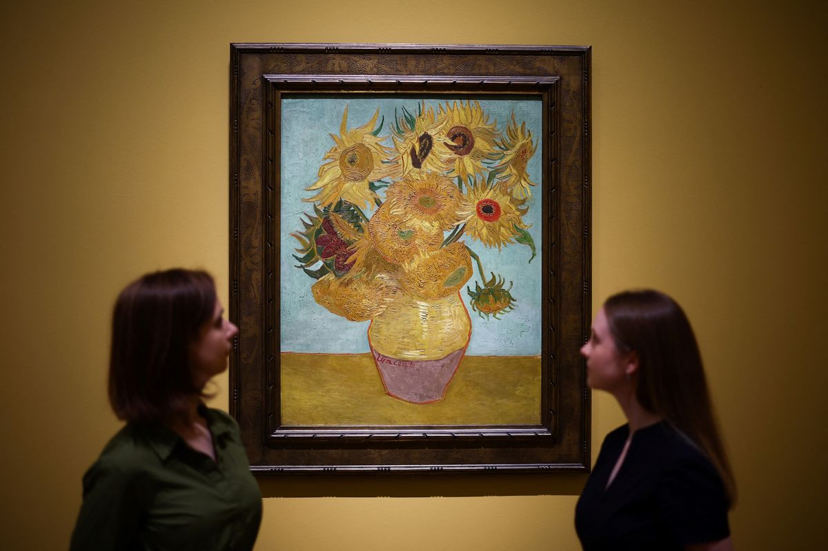 Des visiteurs regardent une peinture de Vincent Van Gogh intitulée 'Tournesols' (1889) lors d'une avant-première à la National Gallery de Londres, le 9 septembre 2024.