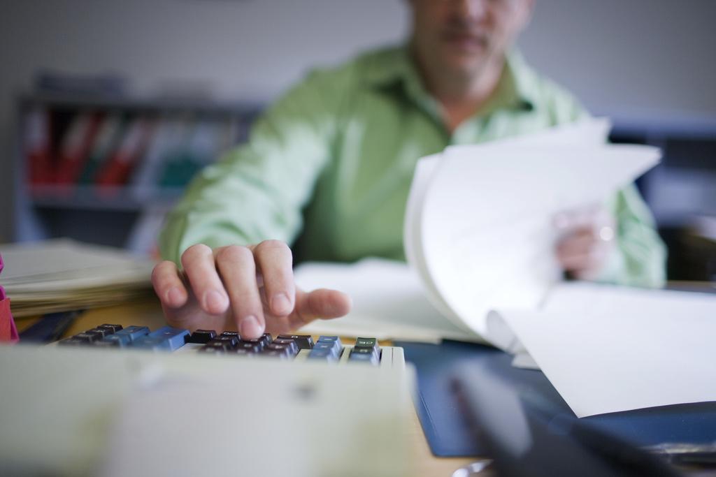 An official of the canton of St. Gallen's tax administration uses a calculator, pictured on January 18, 2010 in St. Gallen, Switzerland. (KEYSTONE/Gaetan Bally)

Ein Beamter des Kantonalen Steueramts St. Gallen benutzt einen Rechner, aufgenommen am 18. Januar 2010 in St. Gallen. (KEYSTONE/Gaetan Bally)