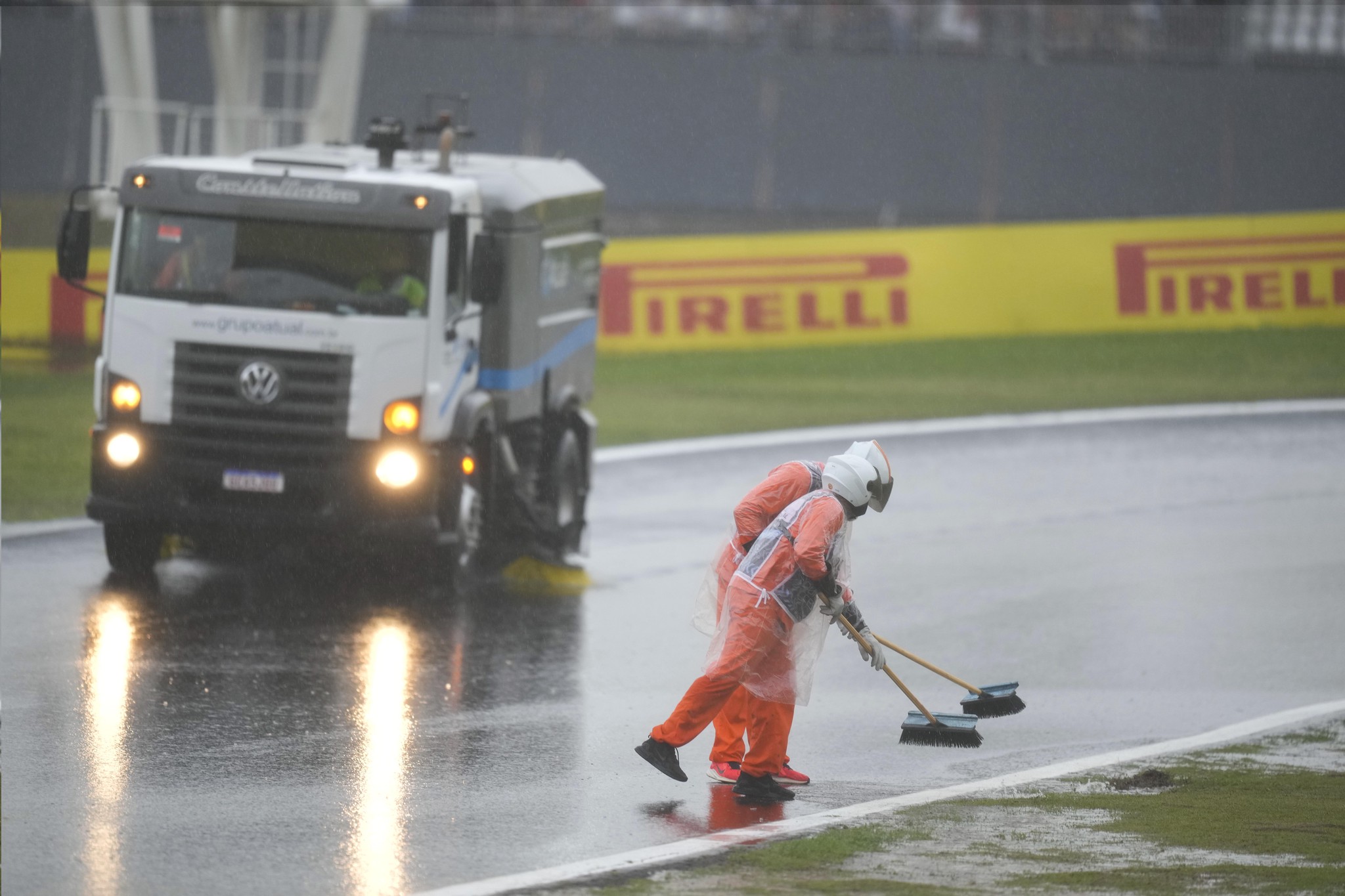 Streckenposten kehren Wasser von der Strecke nach Regenverzögerung beim Qualifying der Formel 1 in Interlagos, Sao Paulo, November 2024.