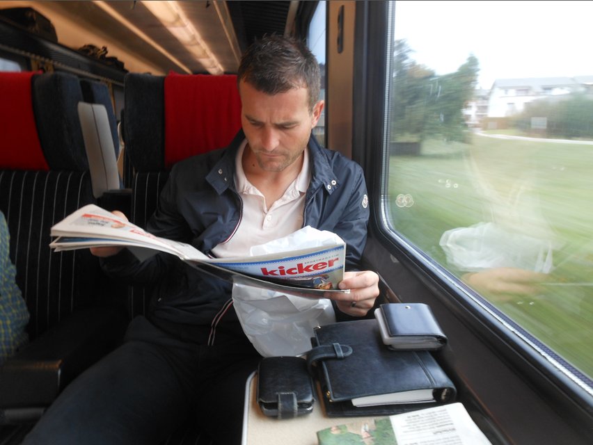 Zugfahrt: Alex Frei studiert in der 1. Klasse diverse Zeitungen und Fachmagazine.