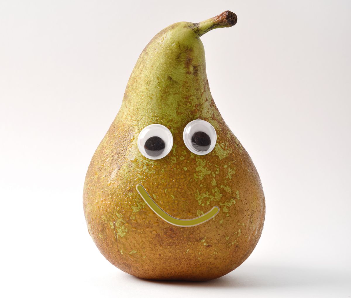 Healthy pear with face on white isolated background. Fruits and vegetables child healthy eating concept