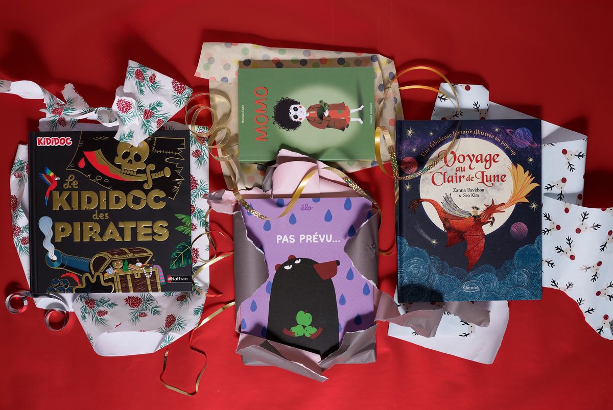 Livres pour enfants emballés pour Noël, dont ’Kididoc des Pirates’, ’Momo’, ’Pas Prévu’, et ’Voyage au Clair de Lune’, sur fond rouge.