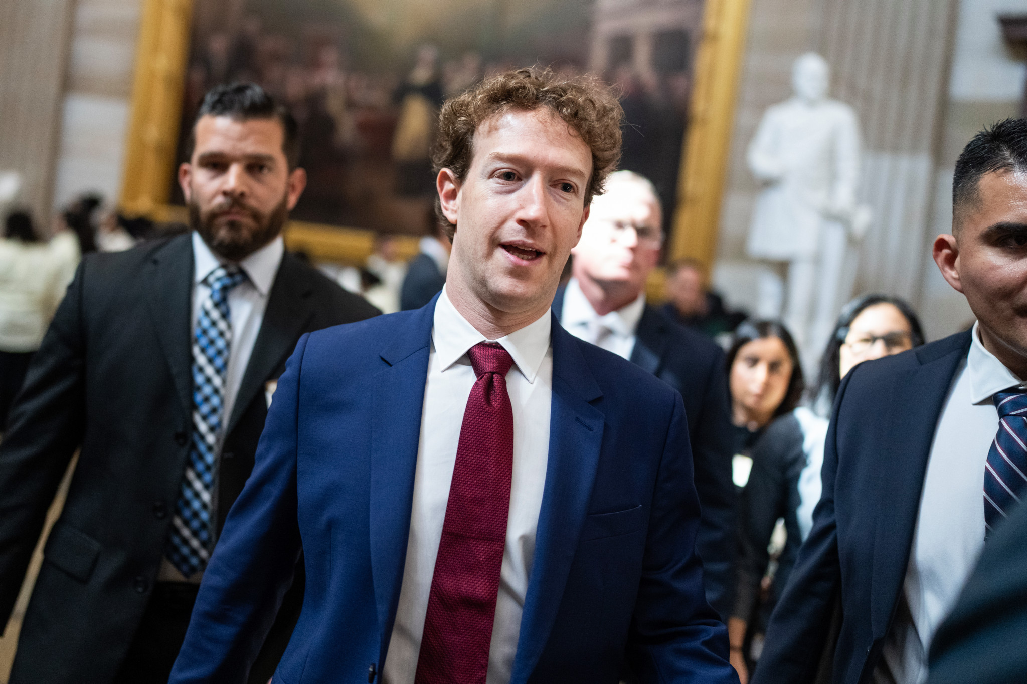 Meta-CEO Mark Zuckerberg im blauen Anzug mit roter Krawatte im US-Kapitol nach einem Treffen mit Senator John Thune.