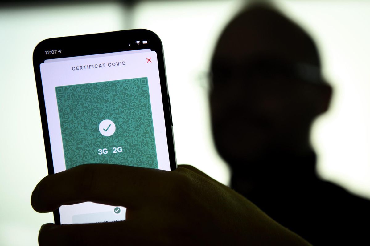 Une personne tient dans sa main un smartphone avec l'application Certificat Covid suisse et son code QR indiquant 3G et 2G, ce lundi, 13 decembre 2021 a Lausanne. (KEYSTONE/Laurent Gillieron)