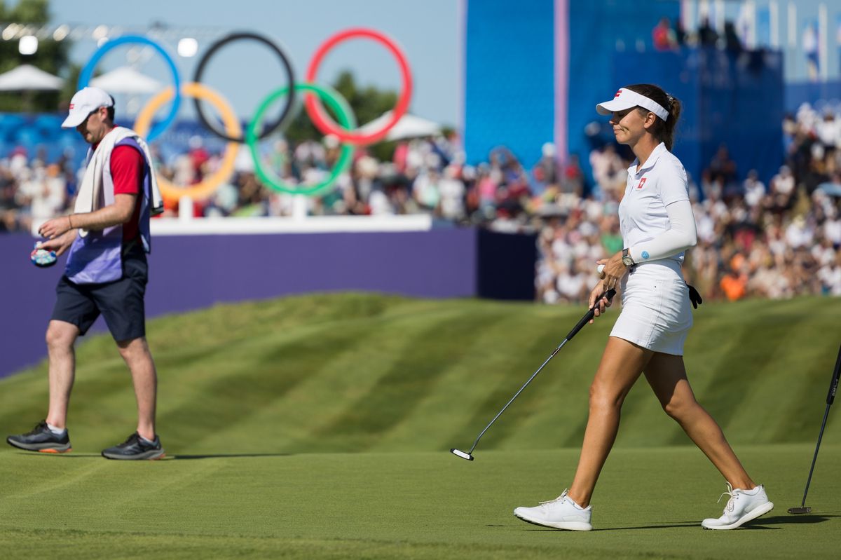 La suissesse Morgane Metraux, au fond les anneaux olympiques, pendant la competition de golf feminin, lors des Jeux Olympiques de Paris 2024, le samedi 10 aout 2024 au Golf National a Magny-les-Hameaux en France (Bastien Gallay / GallayPhoto)