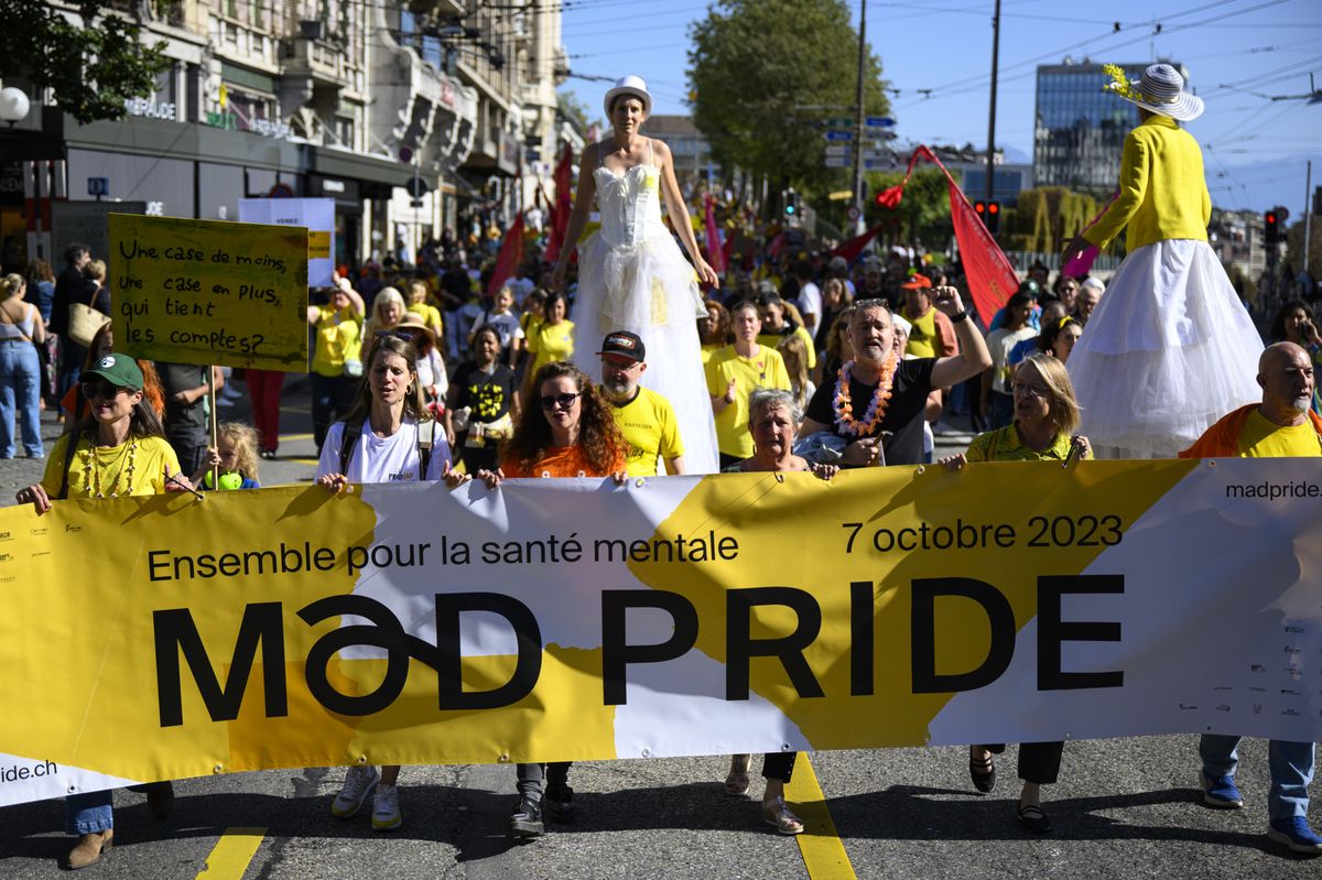People carrying placards and shouting slogans about mental health as they participate in the national march "Mad Pride", in Lausanne, Switzerland, Saturday, October 7, 2023. Around a thousand people parades through the streets of Lausanne during the Swiss Mad Pride on the occasion of the upcoming World Mental Health Day (10 October). This festive gathering aims to destigmatize the psychic illness, the people who suffer from it and their relatives. (KEYSTONE/Laurent Gillieron)