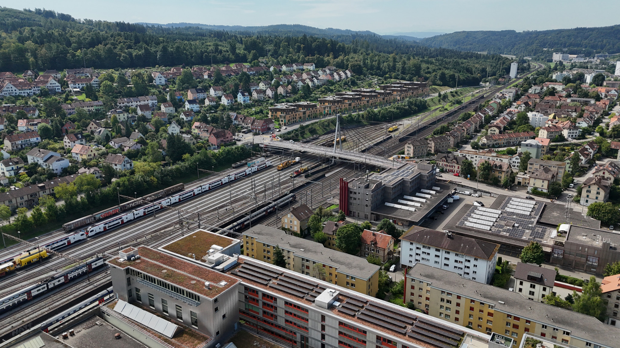 Luftaufnahme der Storchenbrücke mit Zugschienen und angrenzenden Wohnhäusern in Zürich.