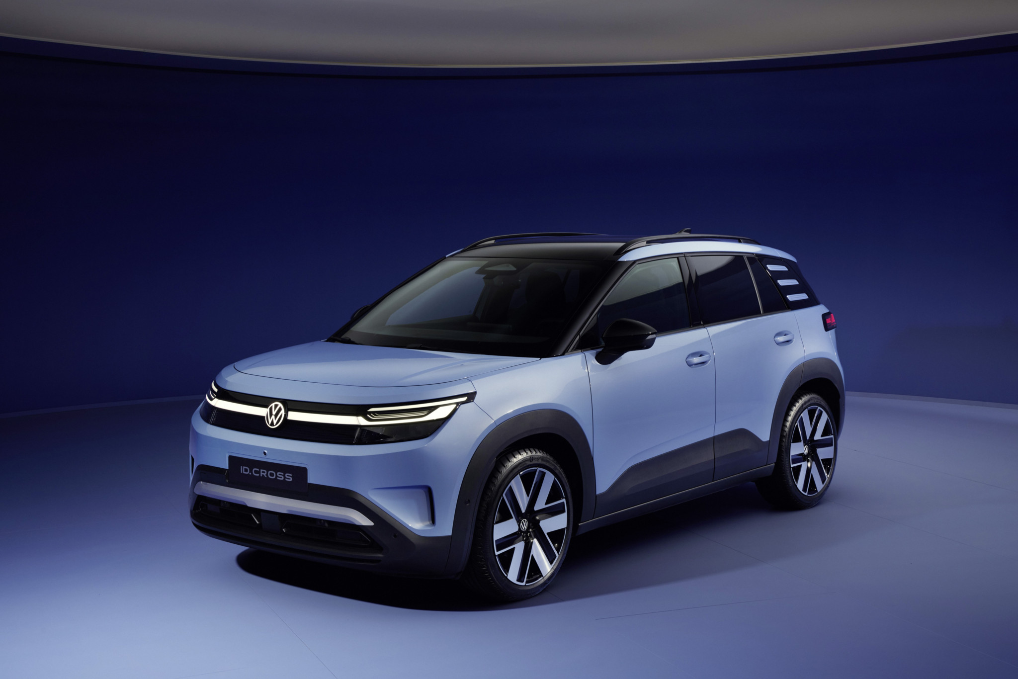 Volkswagen ID.Cross Elektro-SUV in Hellblau, Frontansicht in einem Fotostudio mit blauem Hintergrund.