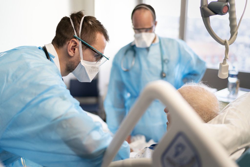 Le personnel soignant prodiguent des soins a une personne atteinte du Covid-19 dans l'unitŽ des soins intermediaires du service de medecine interne lors de la 5eme vague de la pandemie de Coronavirus (Covid-19) le mardi 11 janvier 2022 au Centre Hospitalier Universitaire Vaudois, CHUV, a Lausanne. (KEYSTONE/Gaetan Bally)