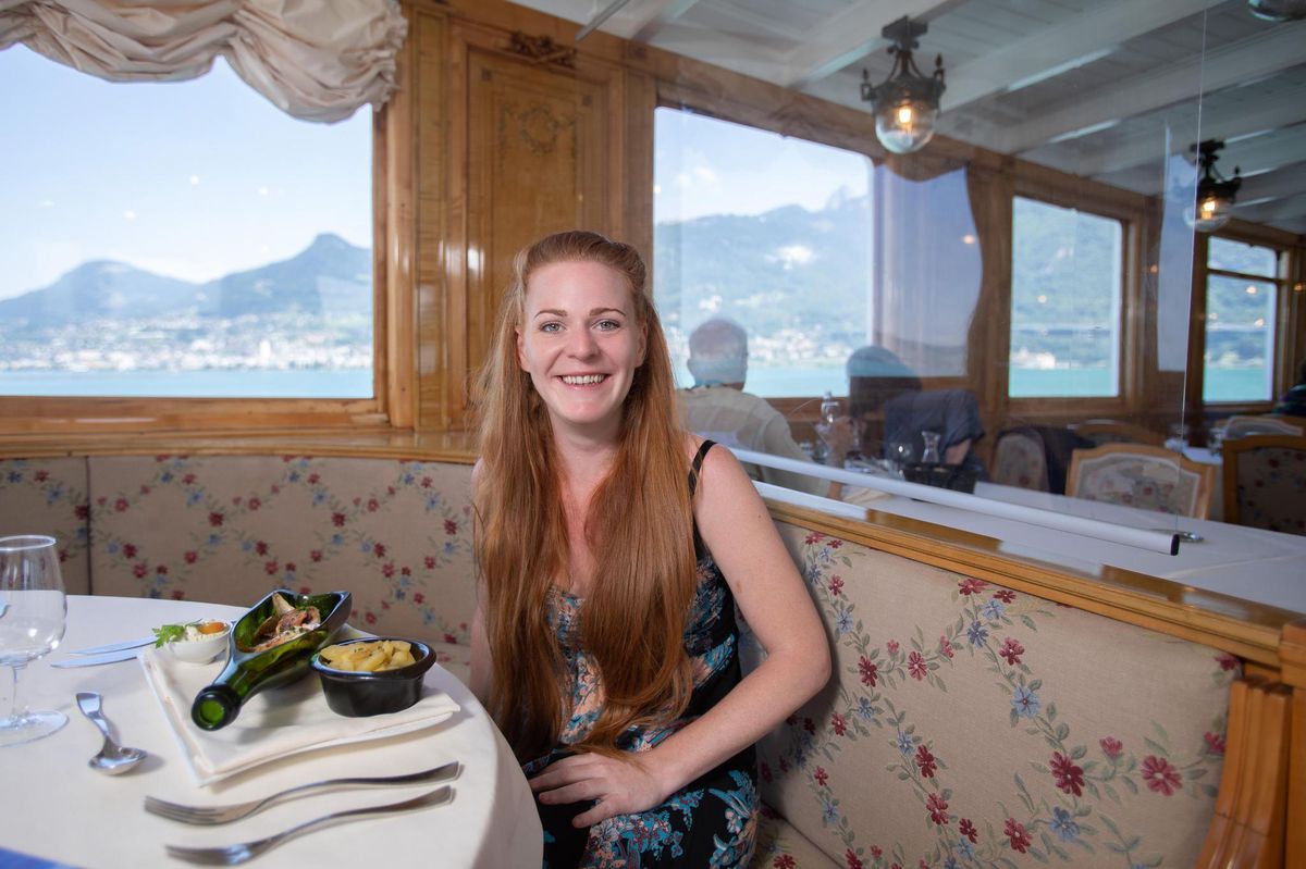Marie Robert dans le salon du bateau la Suisse devant une de ses réalisations, des filets de perches meunières, «bouteille à la mer».