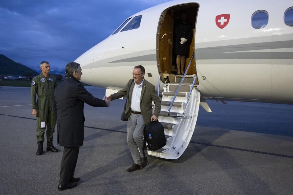Le conseiller fédéral suisse Ignazio Cassis (C) accueille Christian Winter, ambassadeur suisse du Soudan, alors que des ressortissants suisses sont évacués par avion de la zone de crise au Soudan, à l’aéroport de Berne-Belp, le 25 avril 2023.