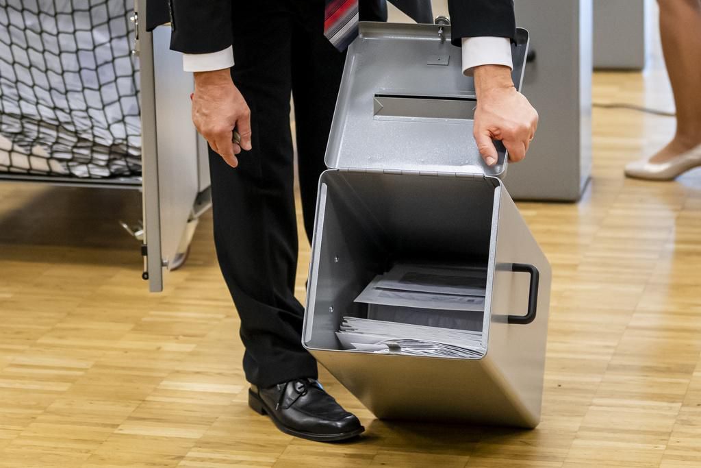 Les observateurs de la Confederation ouvrent une urne au debut du depouillement le dimanche 28 mars 2021 a Moutier. Les citoyens de Moutier doivent decider de l'appartenance cantonale de leur ville. En fin d'apres-midi, la Ville de Moutier saura si elle quitte le canton de Berne pour rejoindre celui du Jura. (KEYSTONE/Jean-Christophe Bott)