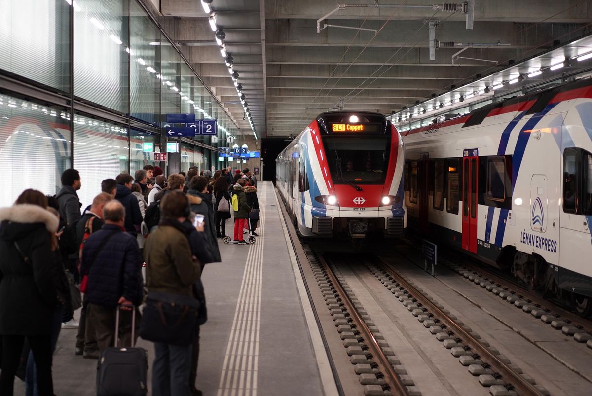 Premiers voyageurs du Léman Express attendent sur le quai de la gare de Chêne-Bourg alors qu’un train arrive.