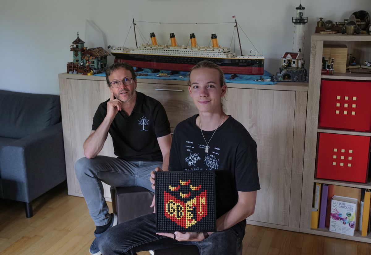 Marc Deshusses et son fils Thomas, entourés de quelques-unes de leurs réalisations en Lego. On reconnaît le Titanic en arrière-plan, et Thomas tient le logo (en Lego!) de leur association GenevaBricks, qu’il a lui-même composé.