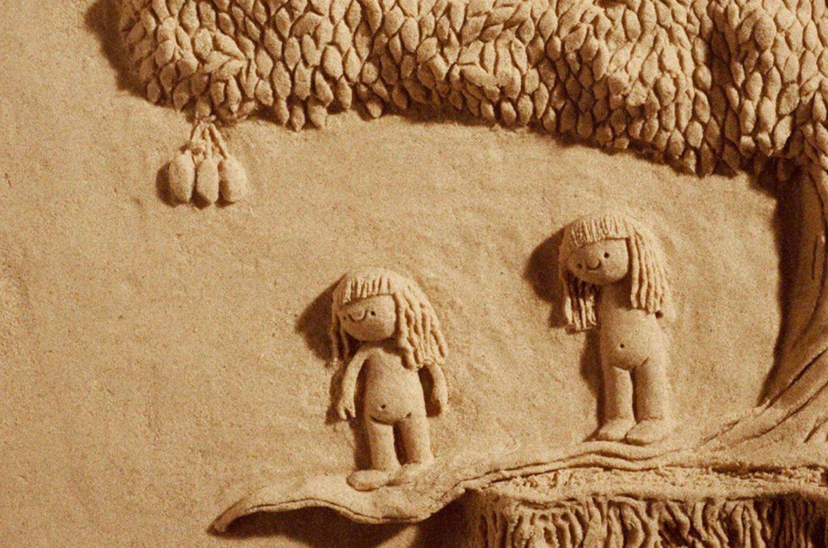 Deux figures enfantines sculptées dans le sable se tiennent sous un arbre dans une scène artistique.