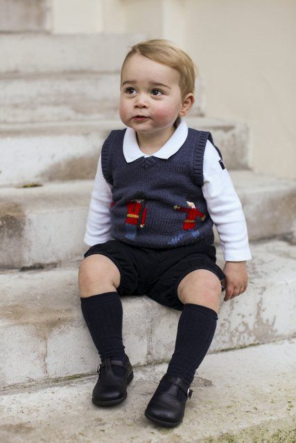 Le prince George pose pour des photographes dans la cour du Kensington Palace à Londres. (novembre 2014)