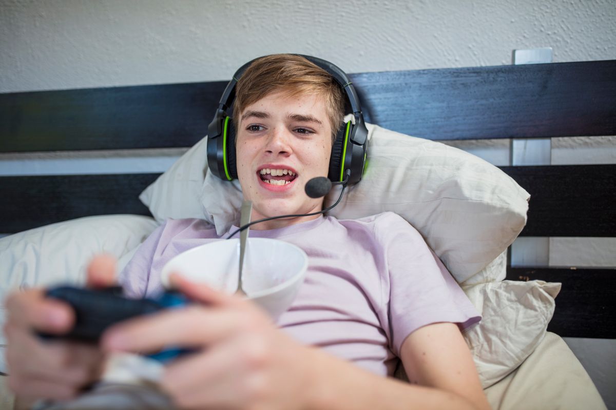 Cape Town, South Africa, Boy in bed playing video games