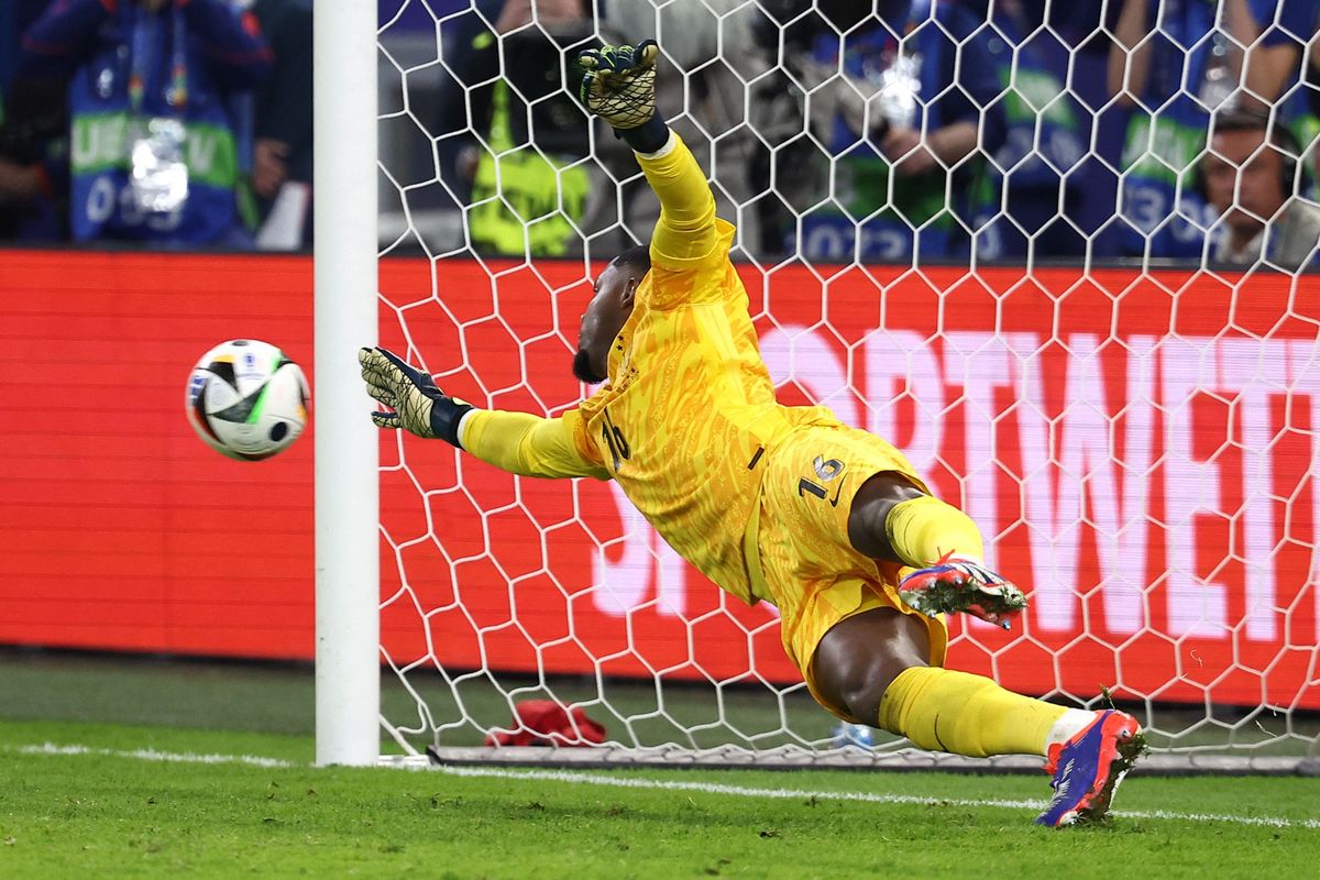 France's goalkeeper #16 Mike Maignan concedes a shot by Portugal's forward #07 Cristiano Ronaldo in a penalty shoot-out during the UEFA Euro 2024 quarter-final football match between Portugal and France at the Volksparkstadion in Hamburg on July 5, 2024. (Photo by FRANCK FIFE / AFP)