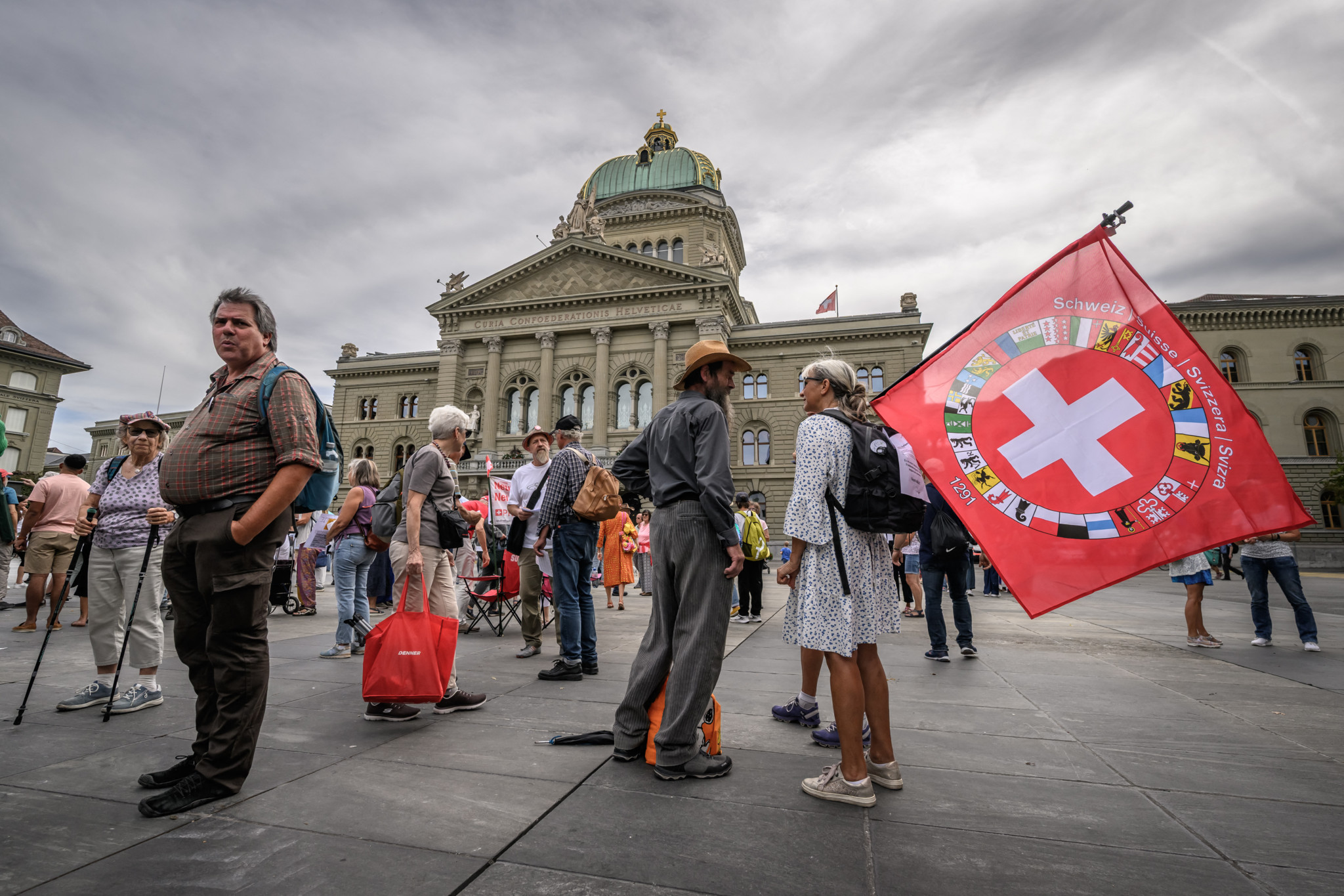 Demonstrierende vor dem Bundeshaus in Bern mit Schweizer Fahne bei einer Kundgebung zur Volksinitiative «Schweizer Neutralität wahren».