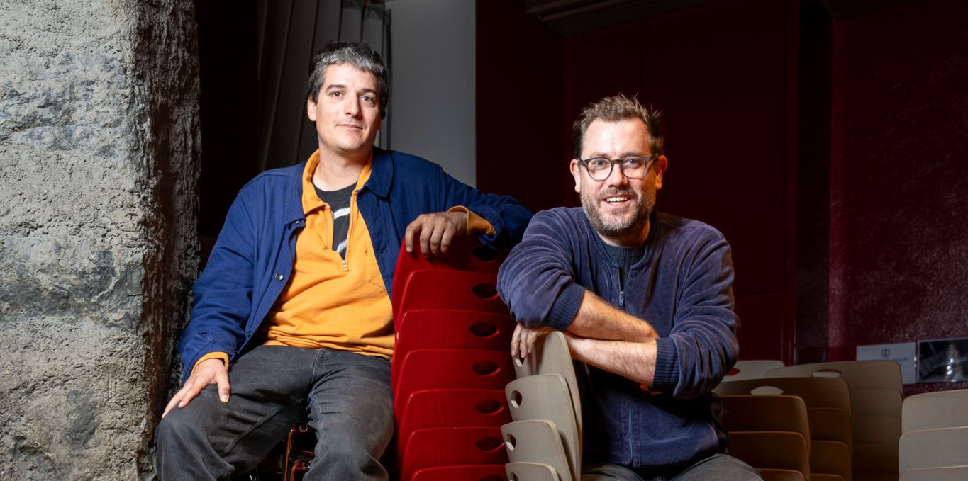 Dimitri Meier et Thibault Walter, co-directeurs artistiques du Lausanne Underground Film Festival, assis sur des chaises empilées.