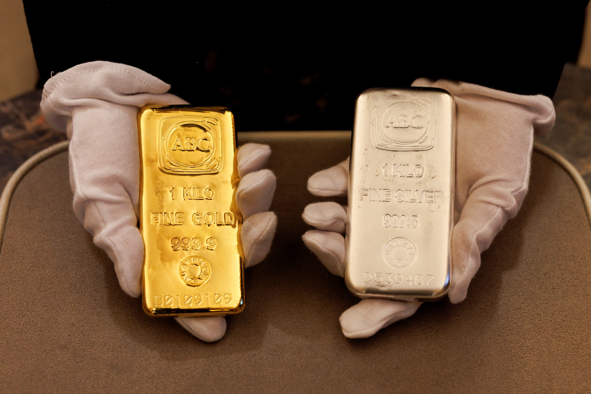 Ein Mitarbeiter hält eine ein Kilogramm schwere Gold- und Silberbarren in einem ABC Bullion Geschäft in Sydney, Australien.
