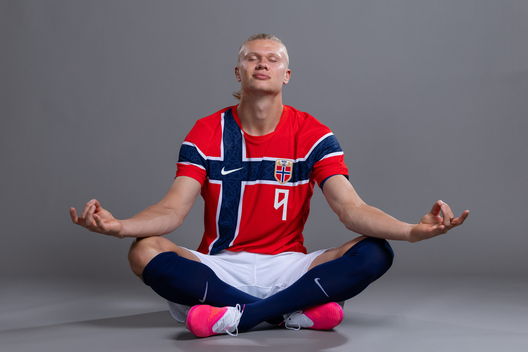 Erling Haaland in Norwegens rotem Trikot mit Nummer 9 sitzt in Yoga-Pose beim offiziellen FIFA WM 2026 Porträt-Shooting. Erling Haaland in Norwegens rotem Trikot mit Nummer 9 sitzt in Yoga-Pose beim offiziellen FIFA WM 2026 Porträt-Shooting.