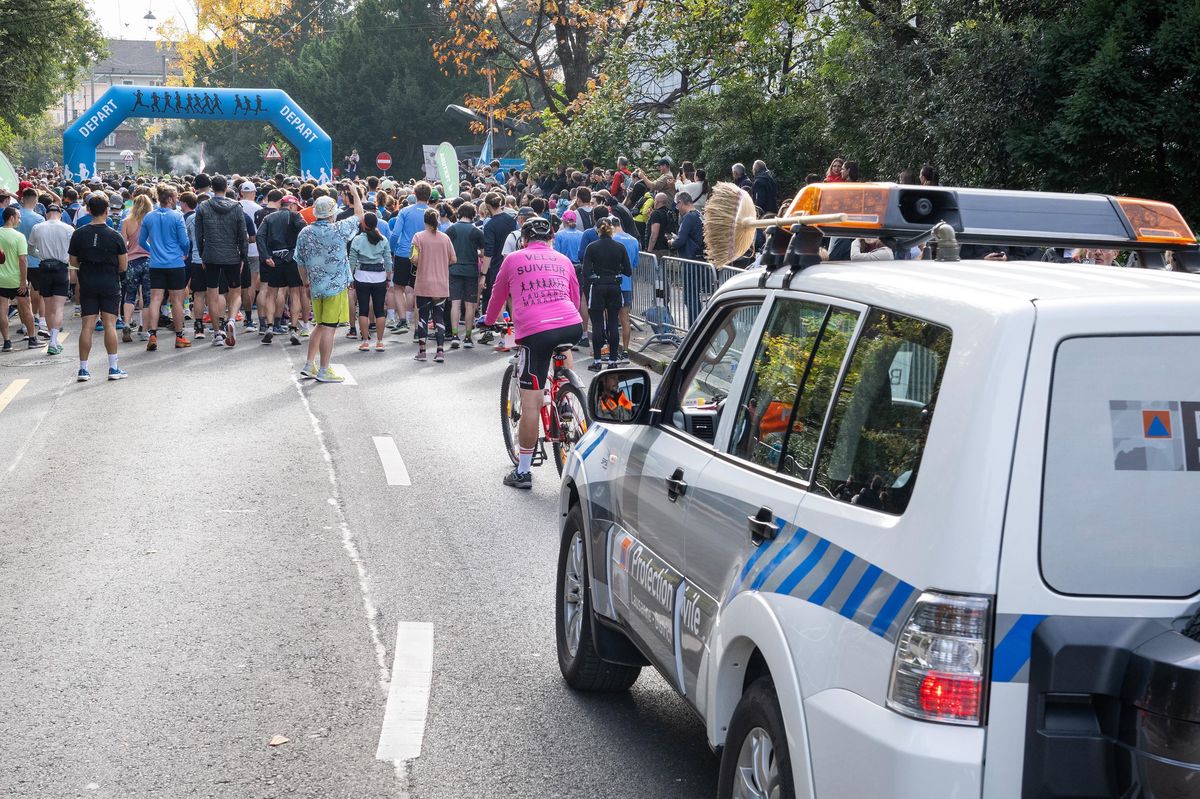 Départ du Marathon de Lausanne avec la voiture balai et Michel Schopfer à vélo en arrière-plan.