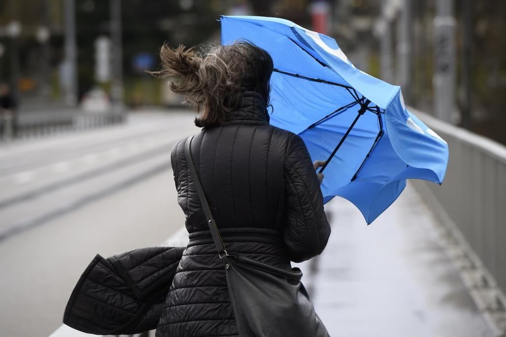 Une femme avec un parapluie dans le vent.