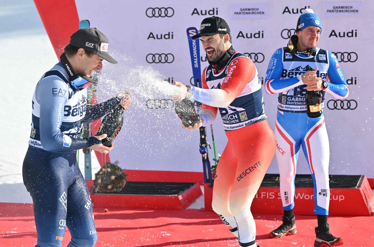 Second placed Italy's Guglielmo Bosca, winner France's Nils Allegre and third placed Switzerland's Loic MeillardSwitzerland's Loic Meillard celebrate with Champagne after the men's Super G event of the FIS Alpine Skiing World Cup in Garmisch-Partenkirchen, southern Germany, on January 27, 2024. (Photo by KERSTIN JOENSSON / AFP)