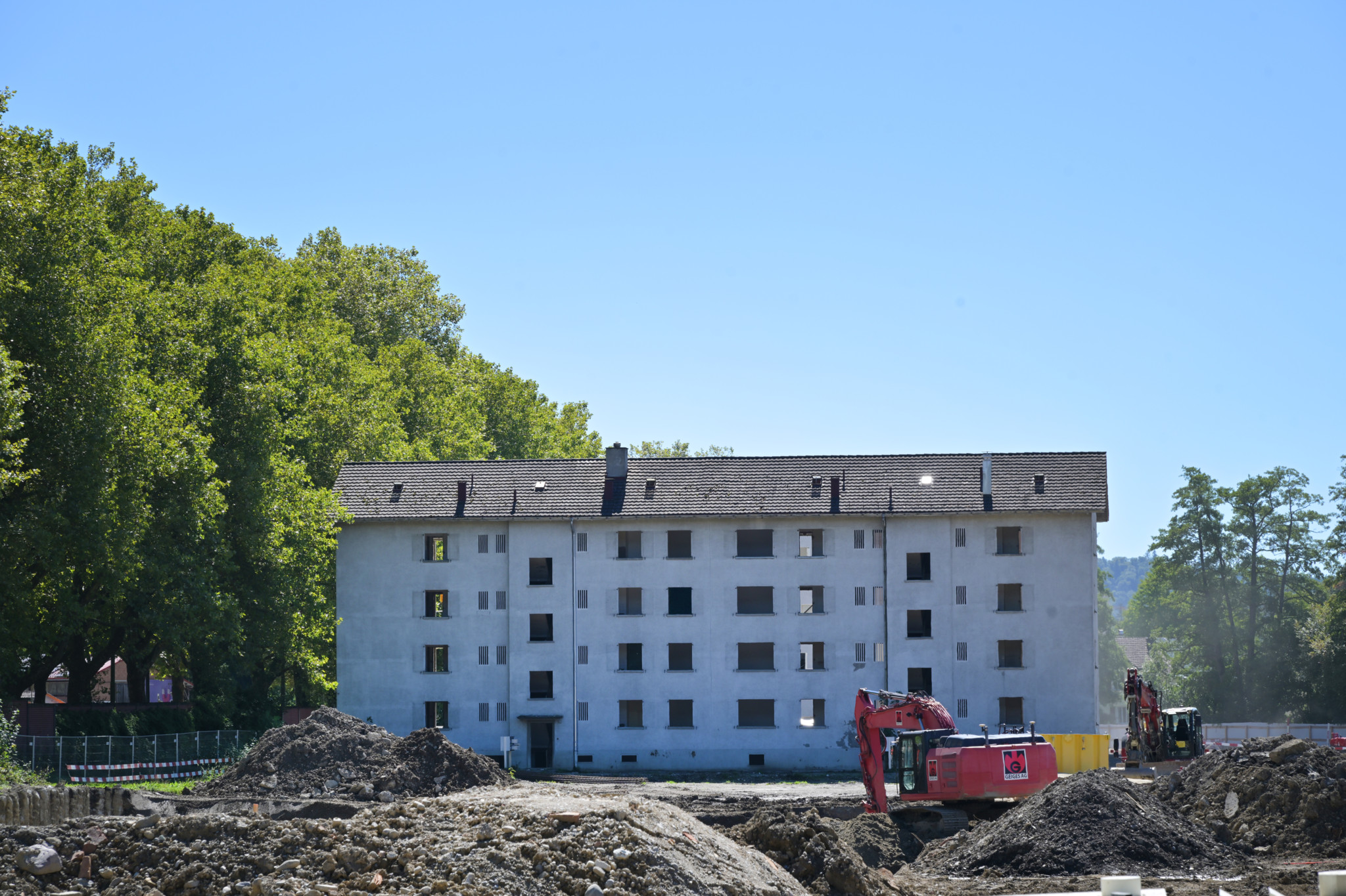 Baustelle der Überbauung Eichwaldhof in Oberwinterthur mit Baggern vor einem Wohngebäude.