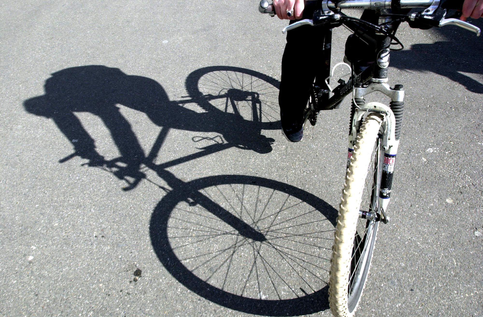 Schatten eines Radfahrers auf einem Fahrrad auf einer sonnigen Strasse in Winterthur. Aufgenommen von Marc Dahinden im Frühling.
