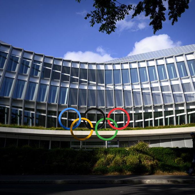 Anneaux olympiques devant la Maison Olympique, siège du Comité International Olympique à Lausanne, Suisse, sous un ciel bleu.
