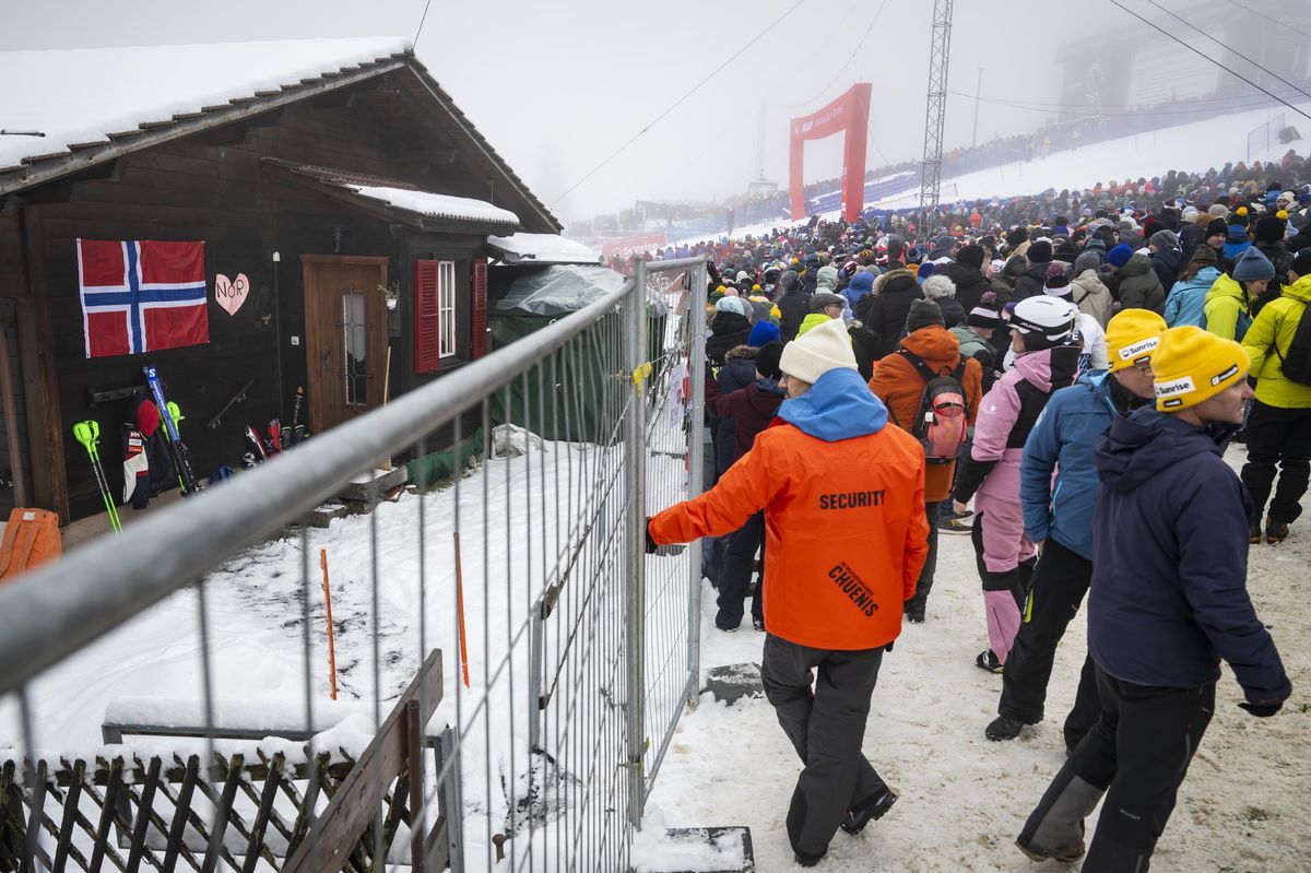 Chalet accueillant l’équipe norvégienne de ski près de la ligne d’arrivée, entouré de spectateurs, lors de la Coupe du Monde FIS de ski alpin à Adelboden, Suisse.