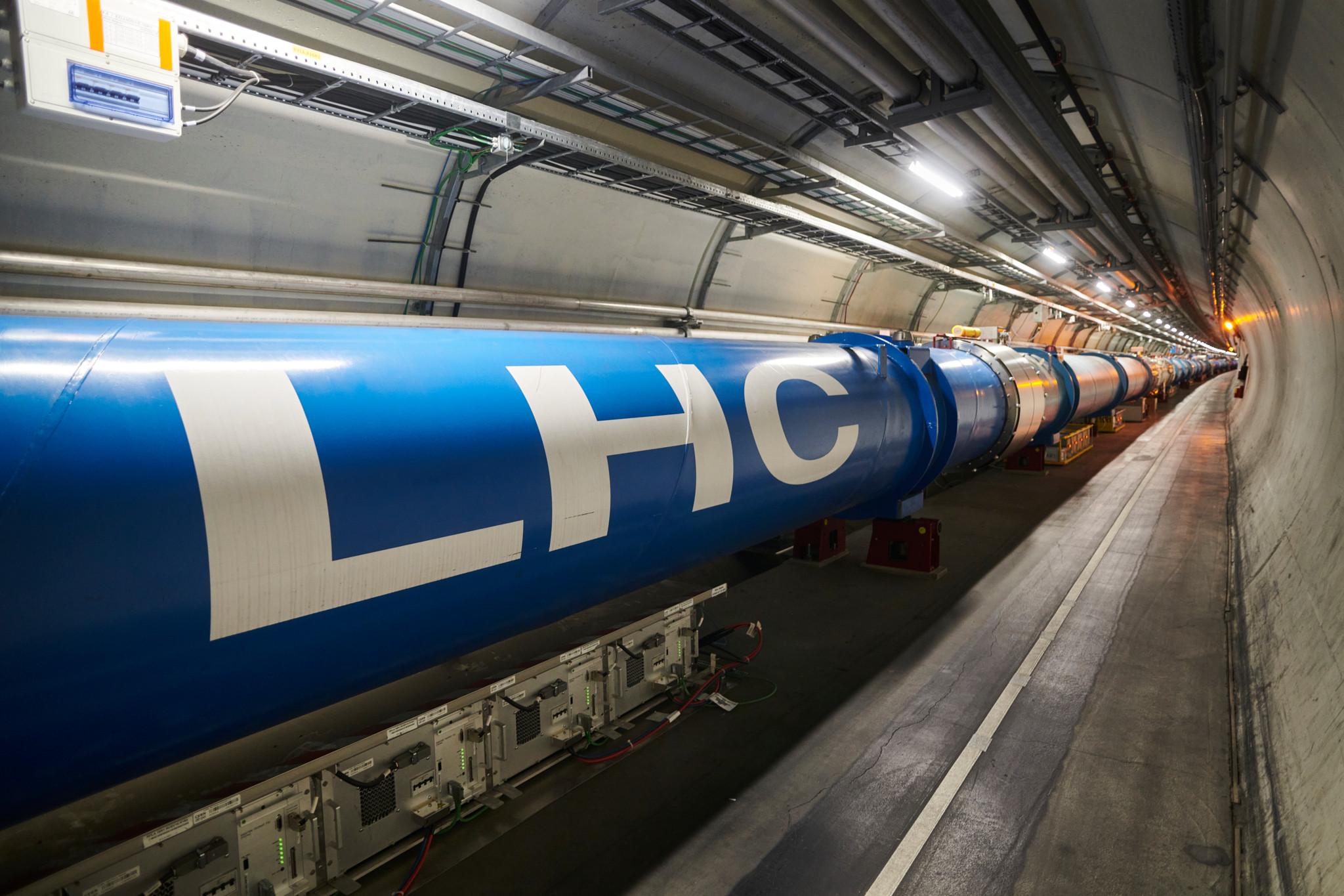 Tunnel du LHC au CERN avec chaîne d’aimants dipôles bleus marqués «LHC» au point 1 (ATLAS), lors du Long Shutdown 2.