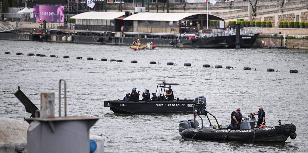 French police officers of the Invervention Brigade (Compagnie d'Intervention) (back) on a boat of the Public Order and Traffic Department (DOPC - direction de l’ordre public et de la circulation) and Police officers from River Brigade (Brigade Fluviale) on a boat patrol on the Seine river, on July 23, 2024, ahead of the Paris 2024 Olympic and Paralympic Games. (Photo by CARL DE SOUZA / AFP)