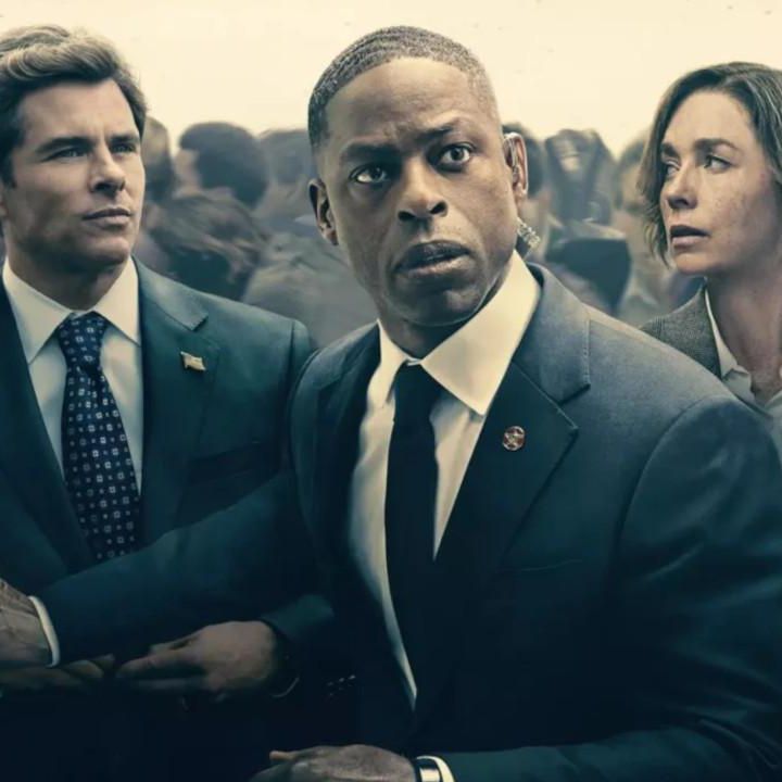 Des personnes en costumes formels, entourées d’une foule floue en arrière-plan.