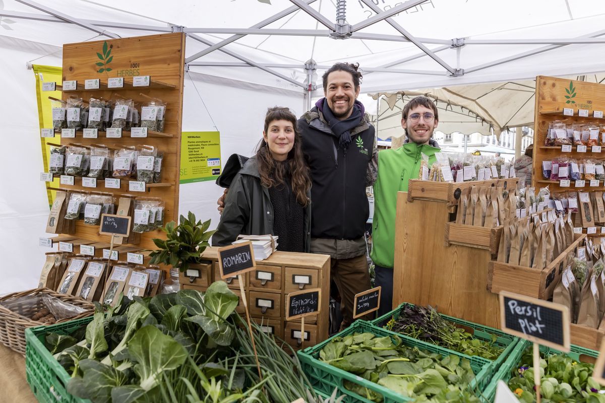  Camille Boschung ( centre ) sur le stand «1001 Herbes» au marché de Rive. 