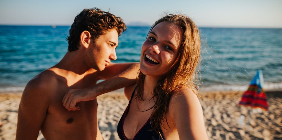Un jeune couple se prend en selfie à la plage. 