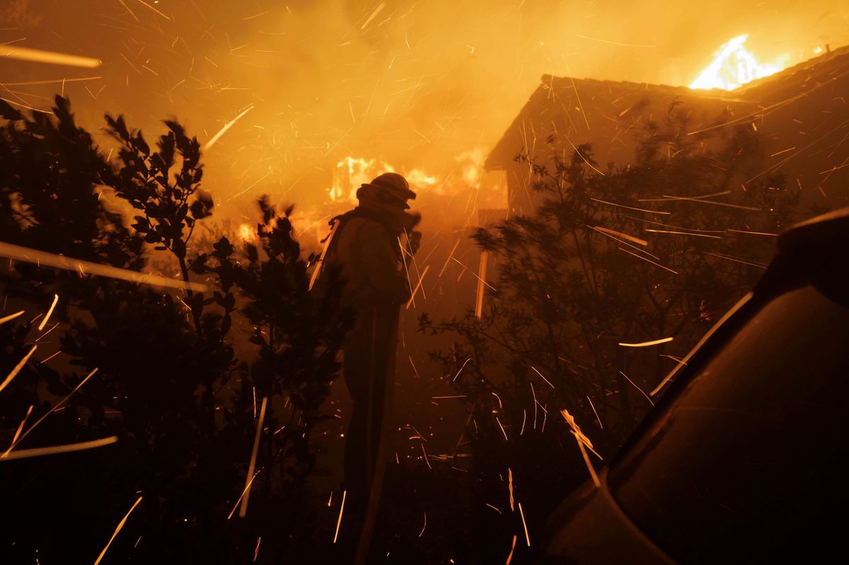 Un pompier s’efforce d’éteindre une maison en feu alors que l’incendie des Palisades se propage rapidement à Pacific Palisades, Los Angeles.