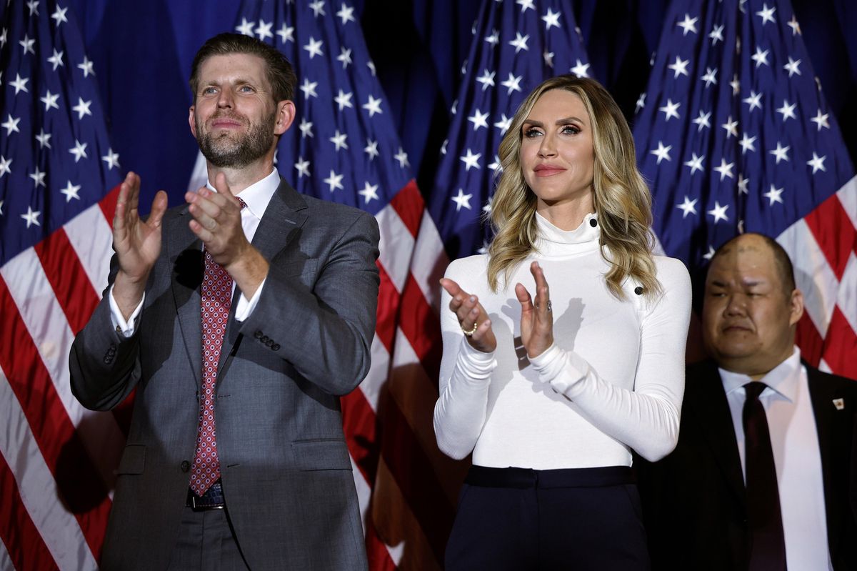 Eric et Lara Trump applaudissent lors d'une soirée électorale au Sheraton à Nashua, New Hampshire, devant des drapeaux américains.