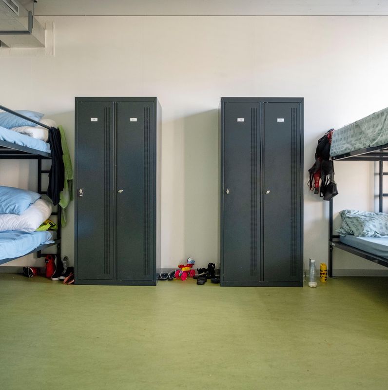 Vue d’une chambre dans le centre fédéral d’asile à Embrach avec lits superposés et armoires.