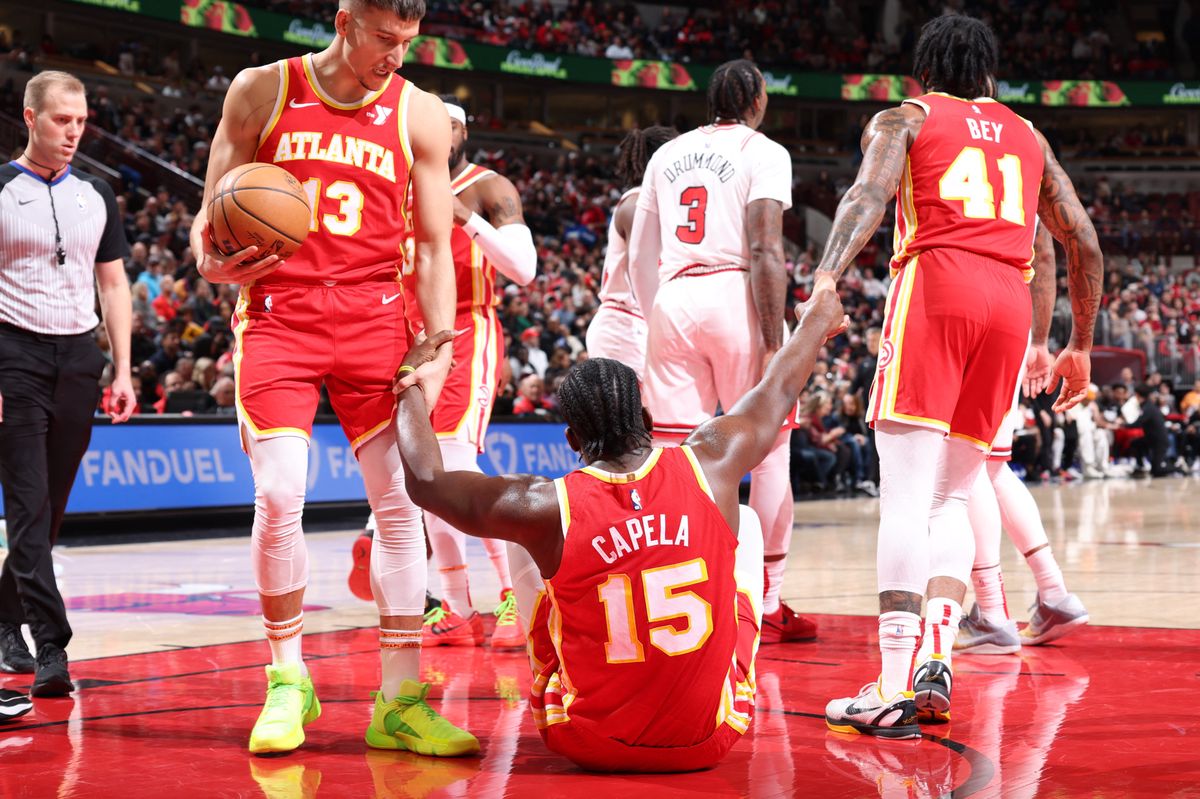 CHICAGO, IL - DECEMBER 26: Clint Capela #15 of the Atlanta Hawks is helped up by Bogdan Bogdanovic #13 and Saddiq Bey #41 during the game against the Chicago Bulls on December 26, 2023 at United Center in Chicago, Illinois. NOTE TO USER: User expressly acknowledges and agrees that, by downloading and or using this photograph, User is consenting to the terms and conditions of the Getty Images License Agreement. Mandatory Copyright Notice: Copyright 2023 NBAE   Jeff Haynes/NBAE via Getty Images/AFP (Photo by JEFF HAYNES / NBAE / Getty Images / Getty Images via AFP)