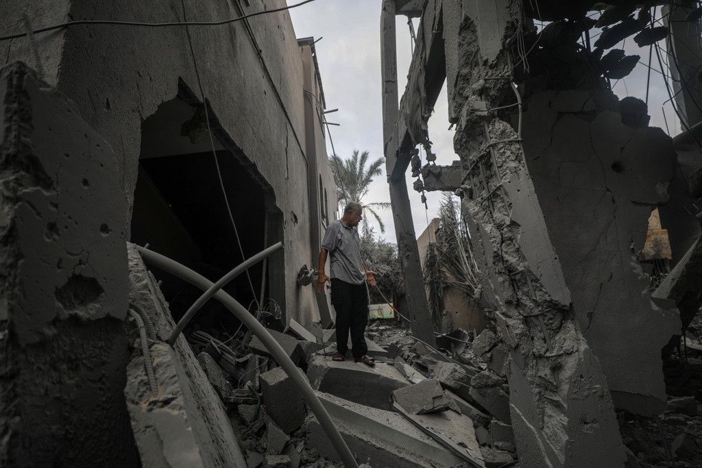 Un homme palestinien inspecte les décombres de la mosquée des Martyrs d'Al Aqsa détruite après une frappe aérienne israélienne à Deir Al Balah, dans la bande de Gaza centrale.