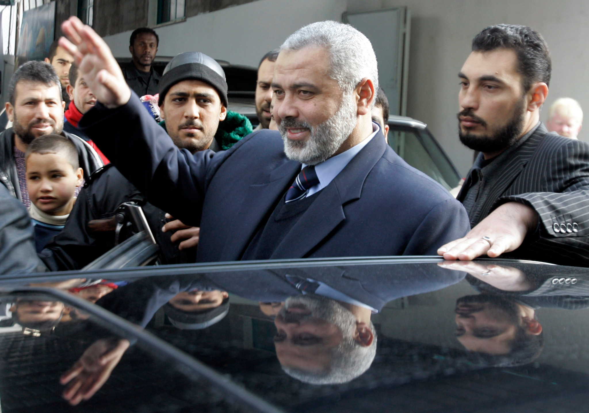 Palestinian Prime Minister Ismail Haniyeh, center, from Hamas waves to supporters outside his house in the Shati refugee camp in the Gaza Strip, Tuesday , Feb. 6, 2007. Haniyeh was on his way to Mecca, Saudi Arabia where a Fatah-Hamas meeting was due to take place later Tuesday. (AP Photo/Hatem Moussa)