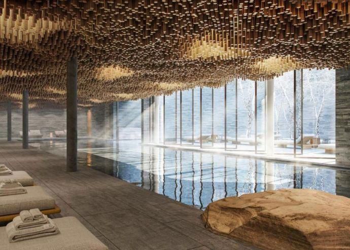 Spa intérieur moderne avec piscine, lumière naturelle entrant à travers de grandes fenêtres, plafond en bois sculpté.